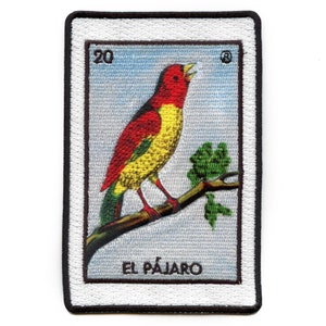May include: A vintage-style embroidered patch featuring a red and yellow bird perched on a branch. The patch has a white background with a black border and the text "EL PÁJARO" at the bottom.