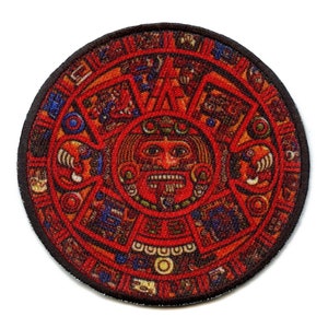 May include: A round, red, black, and blue embroidered patch with a detailed image of the Aztec calendar, also known as the Sun Stone.