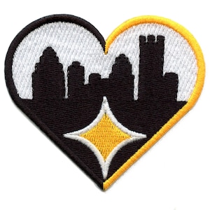 May include: Black and yellow embroidered patch in the shape of a heart. The heart is divided in half, with a black silhouette of a city skyline on one side and a yellow diamond on the other.