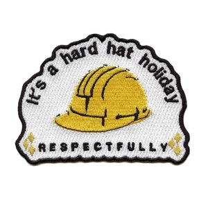 May include: White embroidered patch with a yellow hard hat and the text "It's a hard hat holiday respectfully".