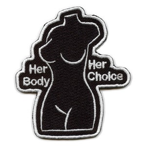 May include: Black and white embroidered patch with a silhouette of a woman's body. The text "Her Body" is on the left side of the patch and "Her Choice" is on the right side.