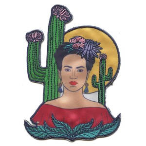 May include: Embroidered patch featuring a portrait of Frida Kahlo with a colorful flower crown, surrounded by green cacti and a yellow sun.