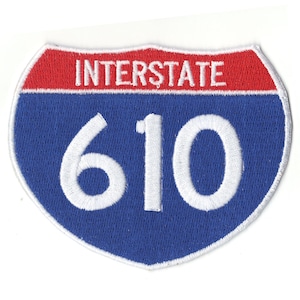 May include: A blue and red interstate highway sign with the number 610 in white.