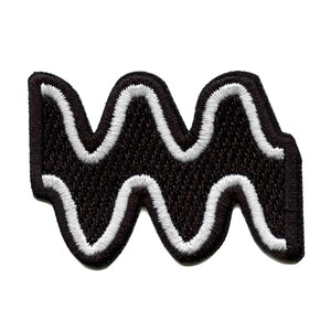 May include: Black and white embroidered patch with a wavy design, resembling water waves.