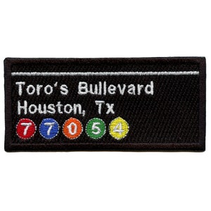 Könnte beinhalten: Schwarzer gestickter Aufnäher mit weißem Text, der "Toro's Boulevard Houston, Tx" lautet, und fünf bunten Kreisen mit den Zahlen 7, 7, 0, 5 und 4.