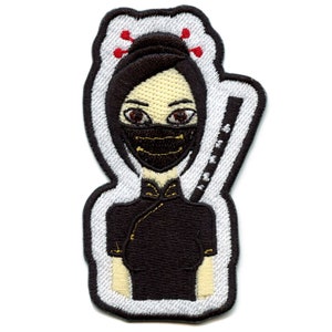 May include: Embroidered iron-on patch featuring a cartoon woman with black hair, wearing a black mask and a black dress with gold accents. She has red hair pins and a sword behind her.