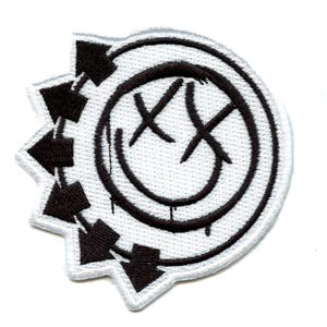 May include: Black and white embroidered patch with a smiley face with an 'X' over the eyes and a black circle around it. The circle is surrounded by a black and white gear with arrows pointing in a clockwise direction.