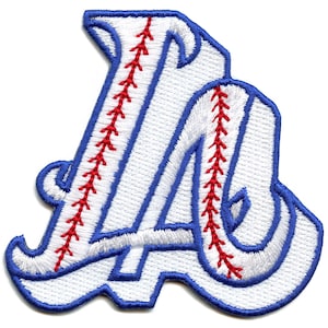 May include: White embroidered patch with a blue outline of the letters "LA" with red stitching resembling a baseball.