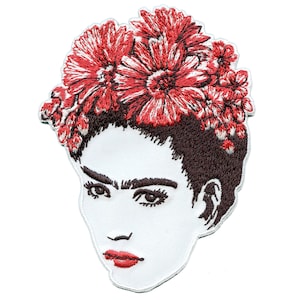Könnte beinhalten: Gestickter Aufnäher mit einem stilisierten Porträt von Frida Kahlo mit einer roten Blumenkrone. Der Aufnäher ist weiß mit braunen und roten Stickereien.