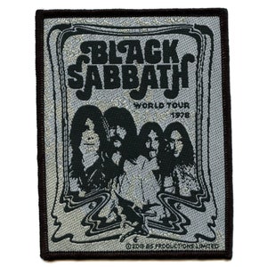 Może przedstawiać: Tkana naszywka Black Sabbath World Tour 1978 z srebrnym tłem i czarnymi napisami. Naszywka przedstawia czarno-białe zdjęcie członków zespołu.