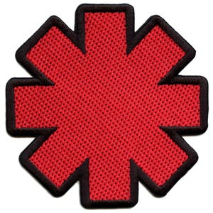 May include: Red embroidered patch in the shape of a six-pointed star with a black outline.