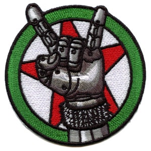 May include: A green circle with a red star inside. A silver hand with a black glove is making the rock and roll hand gesture. The hand is in front of the star.