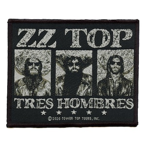 May include: Black and white embroidered patch with the text "ZZ TOP TRES HOMBRES" and three black and white images of the band members. The text "©2020 TOWER TOP TOURS, INC." is at the bottom of the patch.