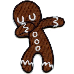 May include: Brown gingerbread man cookie with white icing, doing the dab dance pose.