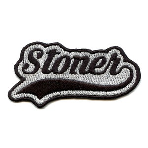 May include: A black and silver embroidered patch with the word "Stoner" in a cursive font.