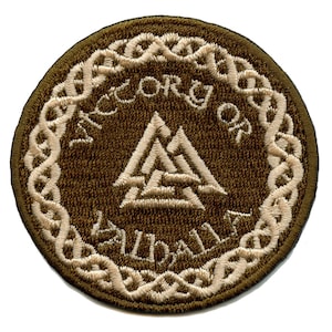 Könnte beinhalten: Ein brauner gestickter Aufnäher mit einem weißen keltischen Knotenrand. Die Mitte des Aufnähers zeigt ein weißes Valknut-Symbol mit dem Text "ACCORD OF VALHALLA" darum herum.