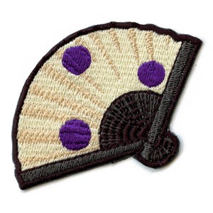 May include: An embroidered patch shaped like a fan with a beige background and three purple circles. The fan is outlined in brown and has a brown handle.