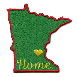 Op de afbeelding: Een geborduurde patch in de vorm van de staat Minnesota. De patch is groen met een rode rand en heeft een geel hart en het woord "Home" in gele letters.