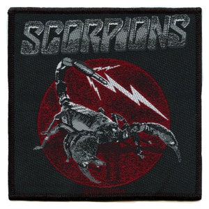 May include: Black and white embroidered patch with the word "SCORPIONS" in a stylized font at the top. A red circle with a white lightning bolt and a black scorpion is in the center of the patch.