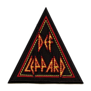 Puede incluir: Parche triangular negro con costuras amarillas y rojas. El texto "Def Leppard" está bordado en amarillo y rojo.