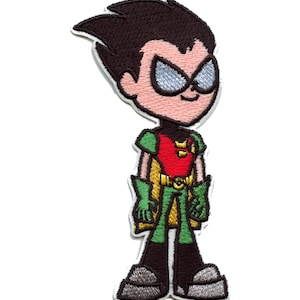 Pode incluir: Etiqueta bordada com uma representação de desenho animado de Robin dos Teen Titans. Robin está vestindo seu traje vermelho, amarelo e verde característico com uma máscara preta e uma expressão determinada.
