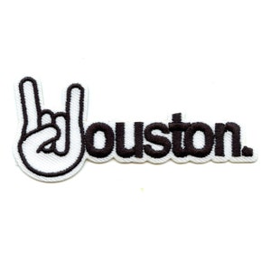 May include: Black embroidered patch with a white hand making the rock and roll hand gesture and the word "Houston" in black.