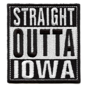 Puede incluir: Parche bordado en blanco y negro con el texto "STRAIGHT OUTTA IOWA" en una fuente en negrita y de bloque.