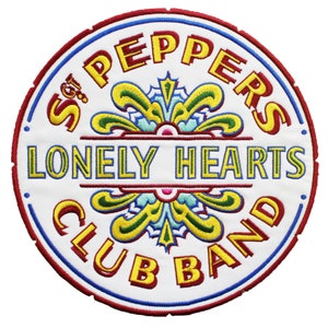 May include: A white embroidered patch with red, blue, and yellow stitching. The patch features the text "Sgt. Pepper's Lonely Hearts Club Band" in a circular design.