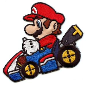 May include: Embroidered patch featuring Mario from the Super Mario Kart video game series. Mario is depicted wearing his signature red cap and overalls, driving a blue kart with yellow wheels.