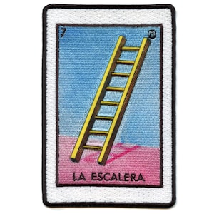 May include: A vintage-style embroidered patch featuring a yellow ladder against a blue sky and pink ground. The patch has a white border and black stitching. The text "LA ESCALERA" is printed below the ladder.