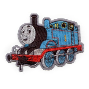 May include: Embroidered patch of Thomas the Tank Engine, a blue train with a red stripe, black wheels, and a smiling face. The number "1" is on the side of the train.