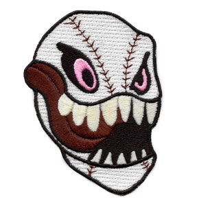 May include: White baseball with a stitched design and a cartoon monster face with a brown mouth and pink eyes. The monster is shown with a wide open mouth and sharp teeth.
