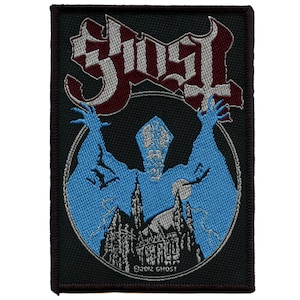 May include: A black embroidered patch featuring the word "Ghost" in white and red lettering. A blue silhouette of a figure with a building in the background is in the centre of the patch. The text "©2012 GHOST" is at the bottom of the patch.