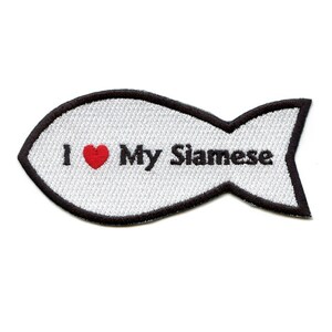 Op de afbeelding: Witte geborduurde patch in de vorm van een vis met een zwarte omtrek. De patch zegt "Ik hou van mijn Siamese" met een rood hart.