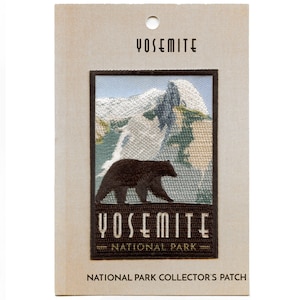 May include: A brown embroidered patch with a black bear walking in front of a mountain scene. The patch says "Yosemite National Park" in brown text.