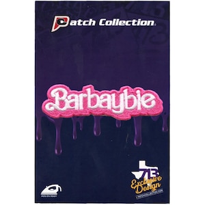 May include: Pink iron-on patch with white text that reads "Barbaybie". The patch has a dripping effect around the edges. The patch is on a purple background with the text "Patch Collection" at the top and "7B Exclusive Design" at the bottom.
