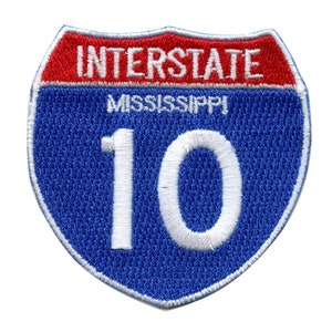 May include: Blue and red interstate highway sign with white text. The sign reads "Interstate Mississippi 10".