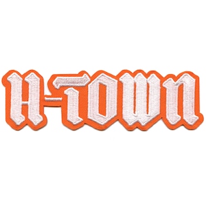 May include: Orange and white embroidered iron-on patch with the text "A-Town" in a gothic font.