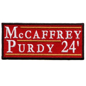 Può includere: Toppa ricamata rossa con testo bianco che recita "McCaffrey Purdy 24'" con due linee dorate sopra e sotto il testo.