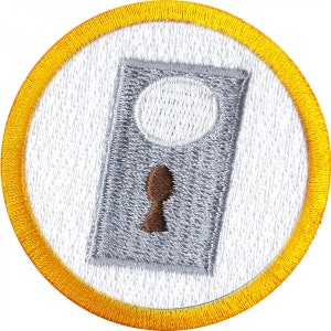 May include: A white embroidered patch with a gray keyhole design. The keyhole has a brown key. The patch is surrounded by a yellow border.