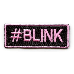 Puede incluir: Parche bordado negro con un hashtag rosa y la palabra "BLINK" en rosa.
