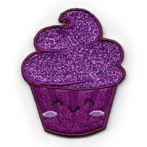 May include: Purple glitter cupcake patch with a smiling face. The cupcake has a swirl of frosting and a white outline.