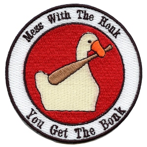 May include: A white goose with a red beak and orange feet holds a wooden baseball bat in its beak. The goose is on a red background with a white circle around it. The text "Mess With The Honk You Get The Bonk" is written in a black circle around the goose.