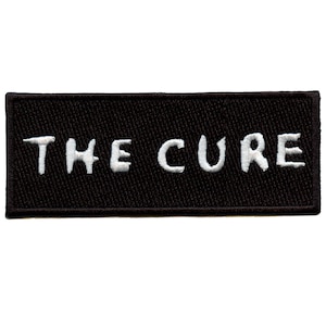 May include: Black embroidered patch with white lettering that reads "THE CURE".