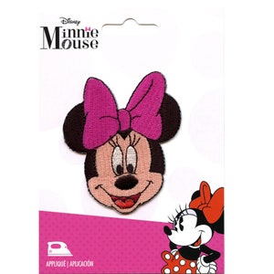 May include: Embroidered Minnie Mouse patch with a pink bow and smiling face. The patch is on a white card with the Disney Minnie Mouse logo. The bottom of the card has the words "APPLIQUÉ | APLICACIÓN" and an iron symbol.