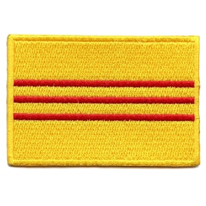 Puede incluir: Parche de tela amarillo con tres rayas horizontales rojas.