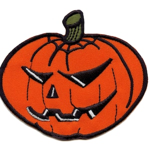May include: An orange and black embroidered pumpkin patch with a scary face. The pumpkin has a black stem and a black outline.