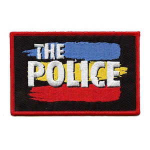 May include: An embroidered patch with the words "THE POLICE" in white lettering on a black background. The words are layered over a red, yellow, and blue paintbrush stroke design.