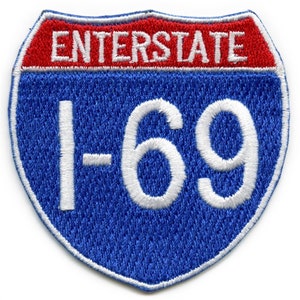 Puede incluir: Una señal de carretera interestatal azul y roja con texto blanco que dice "INTERSTATE I-69".