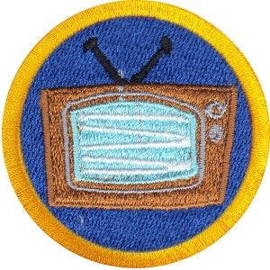 以下が含まれることがあります： アンテナが付いた茶色のビンテージテレビが描かれた青と黄色の刺繍パッチ。テレビの画面は薄い青と白です。